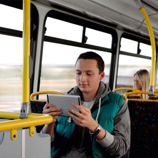 Customer using a tablet on a bus