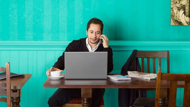 man in coffee shop on laptop