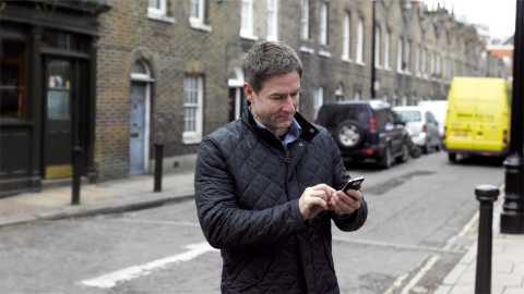 Employee using their smartphone on a pavement