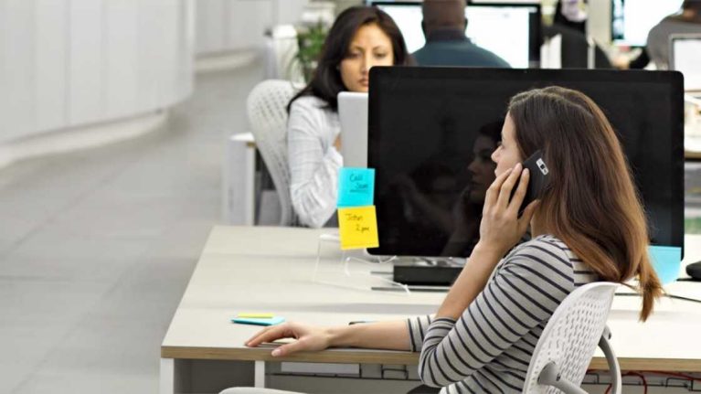 Employee using a mobile at their desk