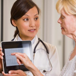 Healthcare professional using tablet device with patient