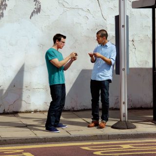 Customers using mobiles on a street