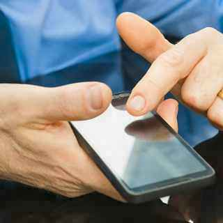 A man uses the touch screen on his EE Business phone