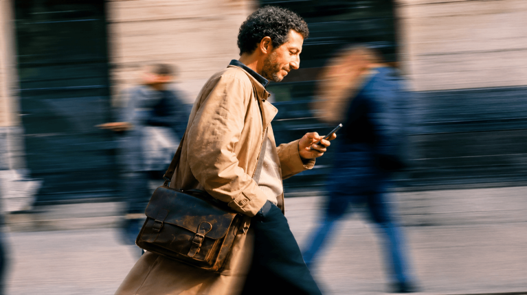 Man walking on busy road with phone