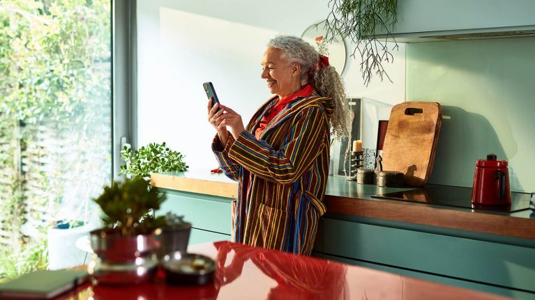 Woman looking at iPhone in kitchen