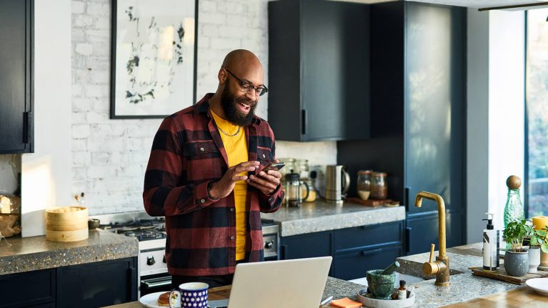 Man using phone in kitchen