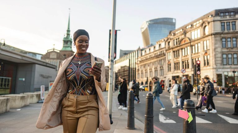 Woman walking outside with phone