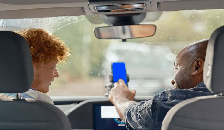 Two men in a van on a phone